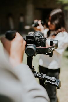 Photographers using stabilizers to capture outdoor shots, emphasizing modern photography techniques.