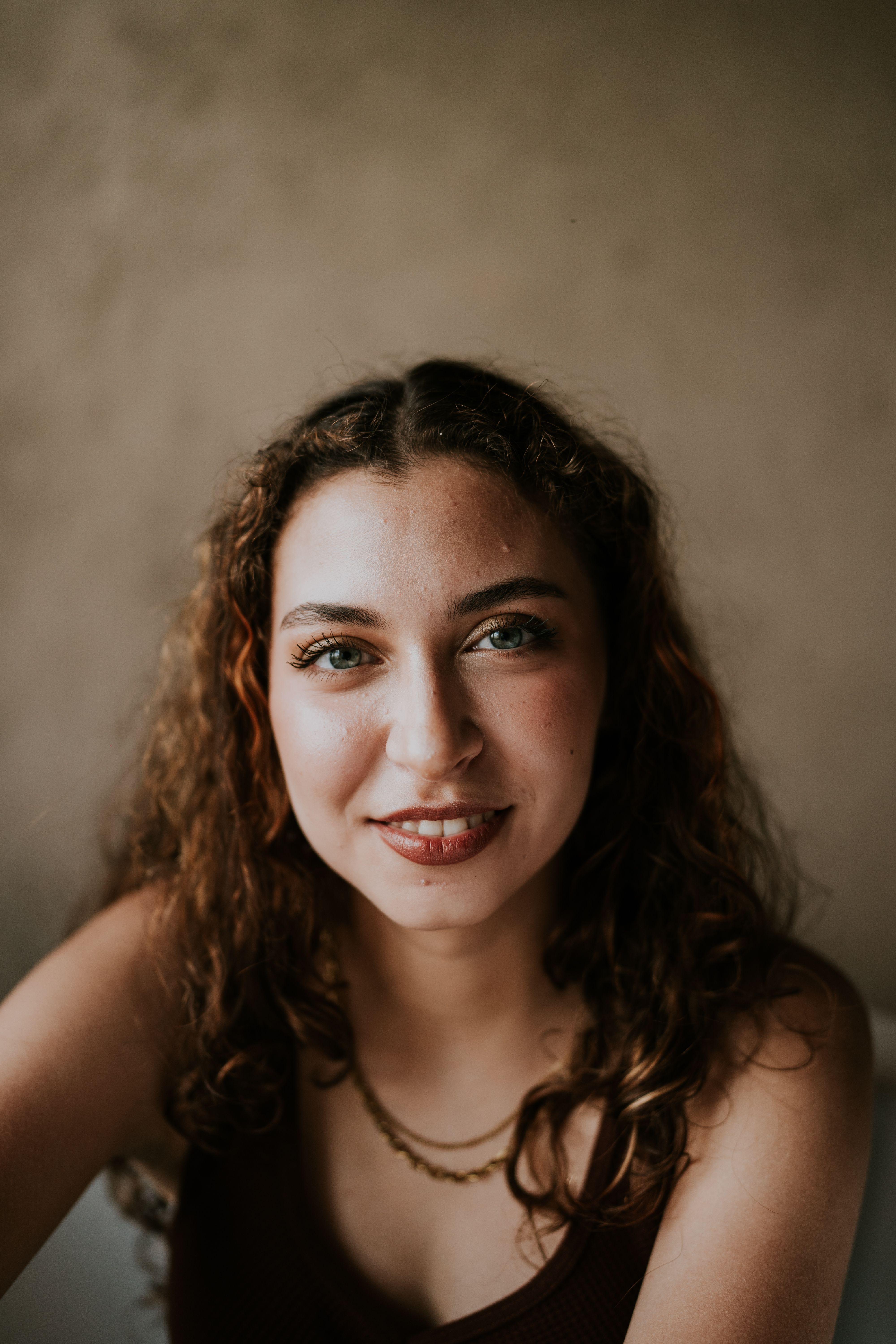 Portrait of a Woman with Curly Hair in Soft Lighting · Free Stock Photo