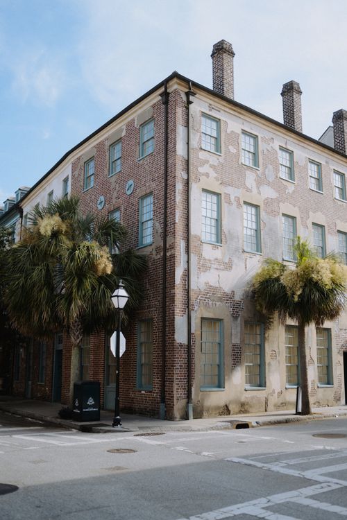 Free Corner view of a vintage brick building with palm trees in Charleston, SC. Stock Photo