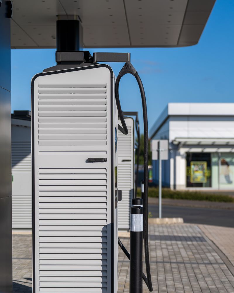 A modern electric vehicle charging station under a canopy.