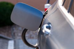 Close-up of an electric car being charged at a station. Sustainability and green technology.