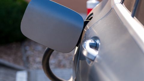 Close-up of an electric car being charged at a station. Sustainability and green technology.