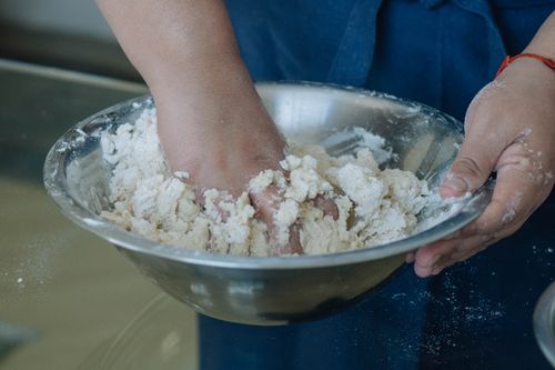 Free Close-up of hands kneading dough in a stainless steel bowl, showcasing the baking process. Stock Photo