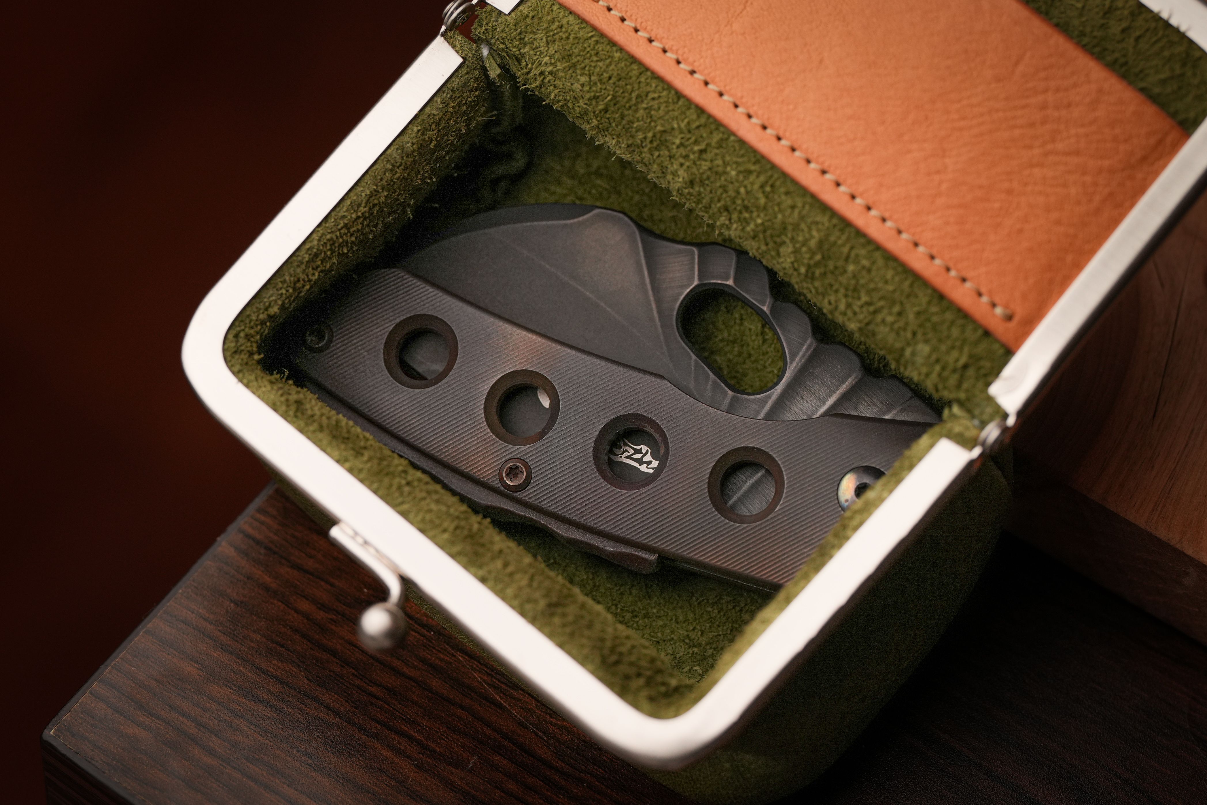 A compact folding knife securely placed in a stylish leather and felt case.