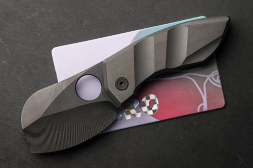 Free Close-up of a sleek tactical black blade placed on a colorful card background. Stock Photo