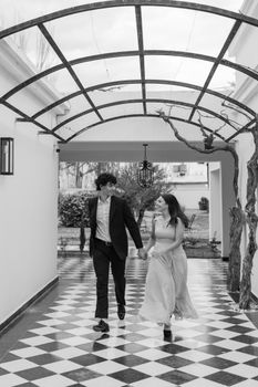 A couple holding hands walking under a pergola in Luján de Cuyo, Mendoza.