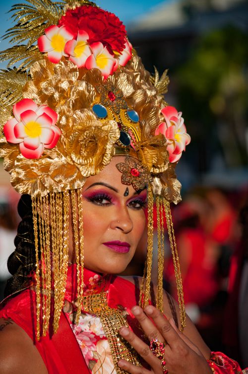 Free Woman in vibrant traditional attire with ornate floral headpiece during a cultural festival. Stock Photo