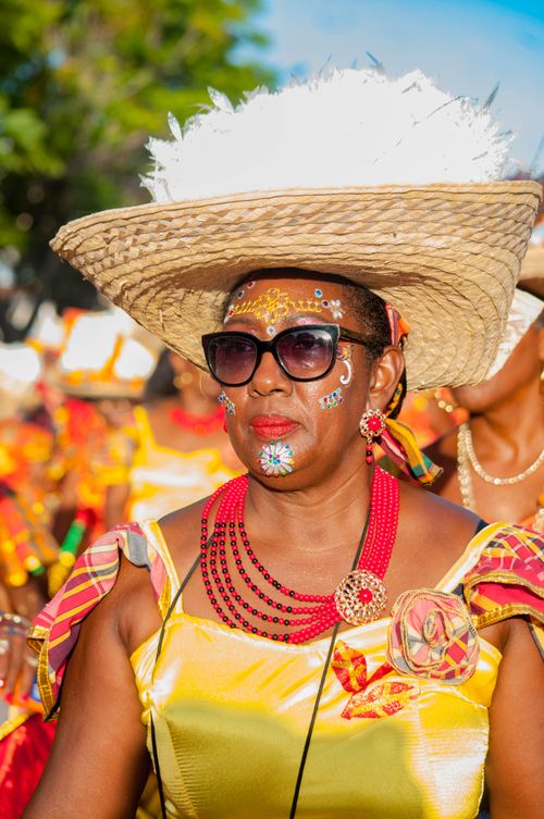 Free Colorful portrait of an adult woman in traditional Caribbean festival attire with face paint and a large hat. Stock Photo