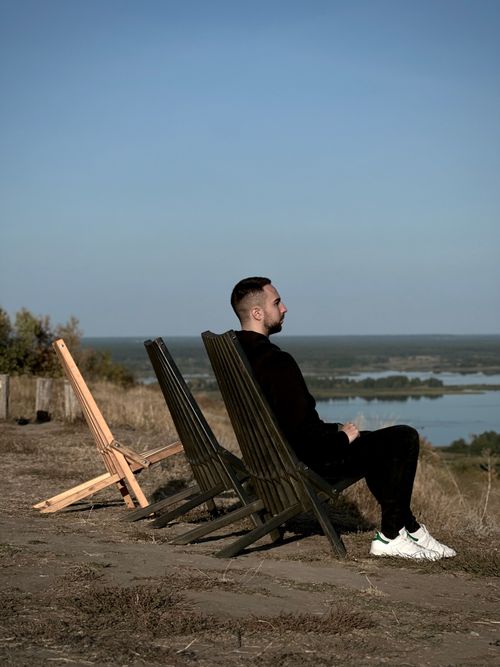 Free Man relaxing on chairs with panoramic view on a sunny day. Stock Photo