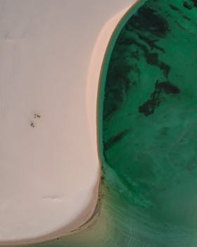 Stunning aerial shot of the unique sand dunes blending with a vivid turquoise lagoon in Maranhão, Brazil.