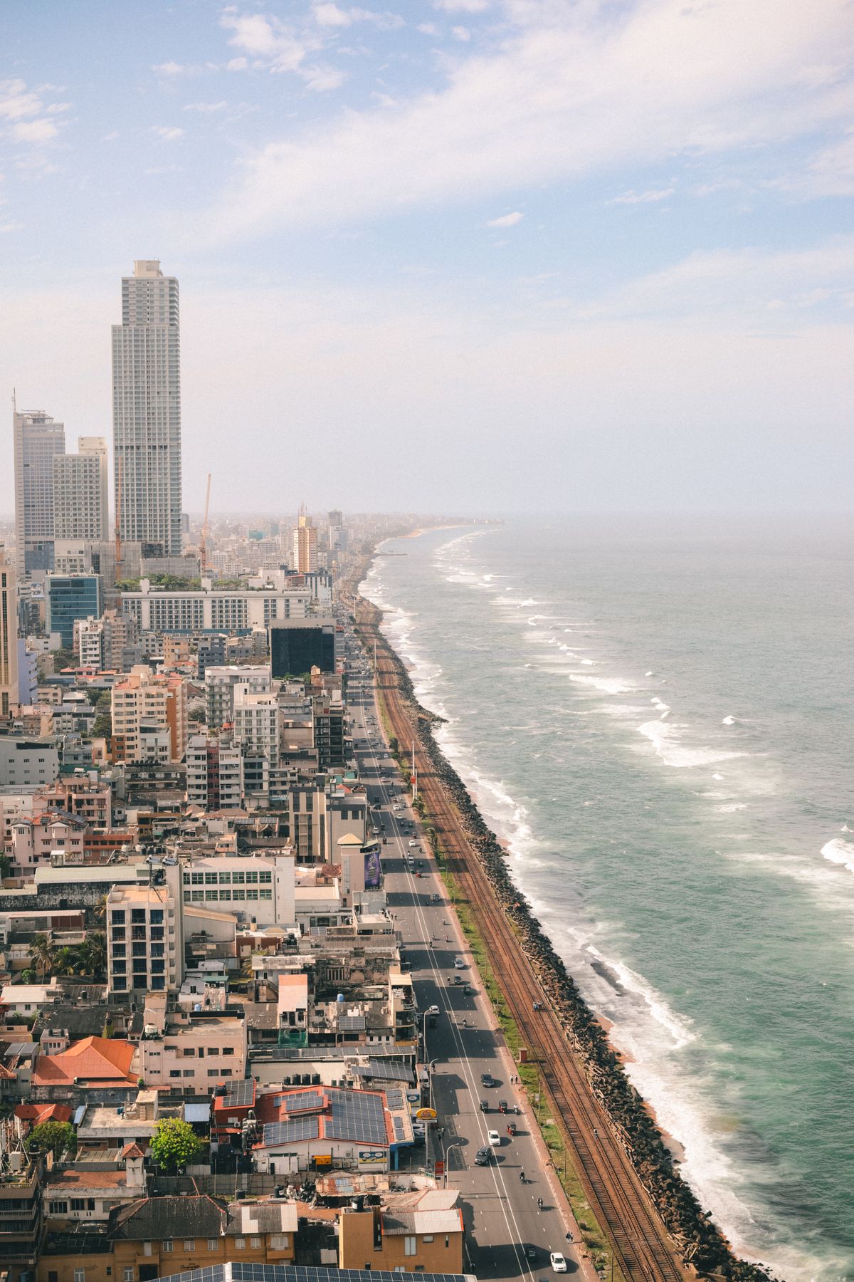 A train running along the coast between Colombo and Galle with the ocean beside the track in Sri Lanka