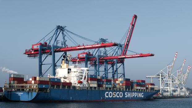 COSCO shipping vessel docked at Hamburg port terminal for global freight transport.