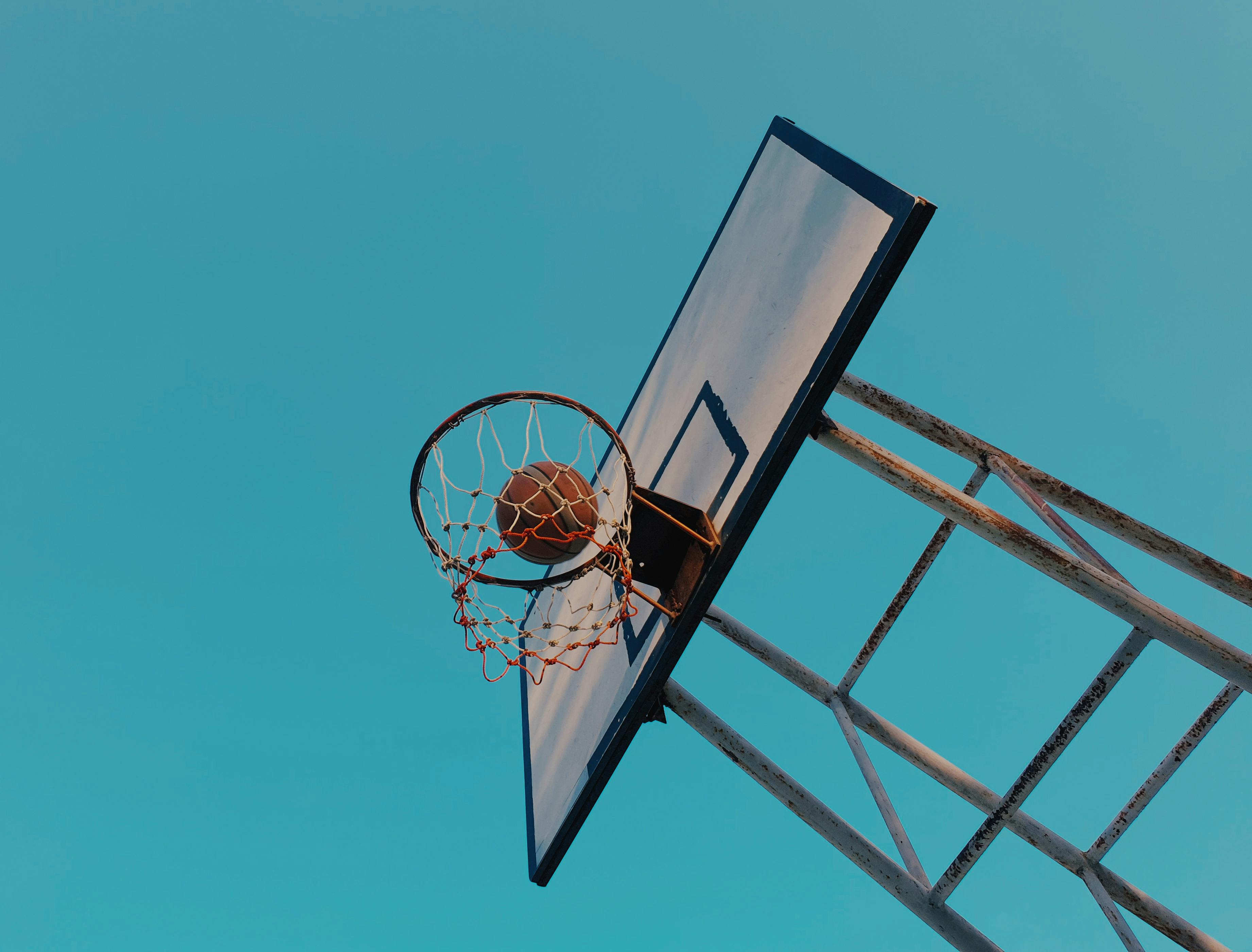 basketball and backboard under blue sky