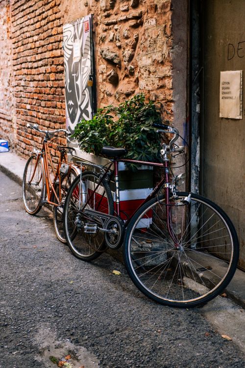 Free Two vintage bicycles parked against a rustic brick wall in Istanbul, capturing urban charm. Stock Photo