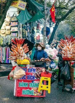 A vibrant street food stall in Vietnam offering grilled delights and bánh tráng nuong.