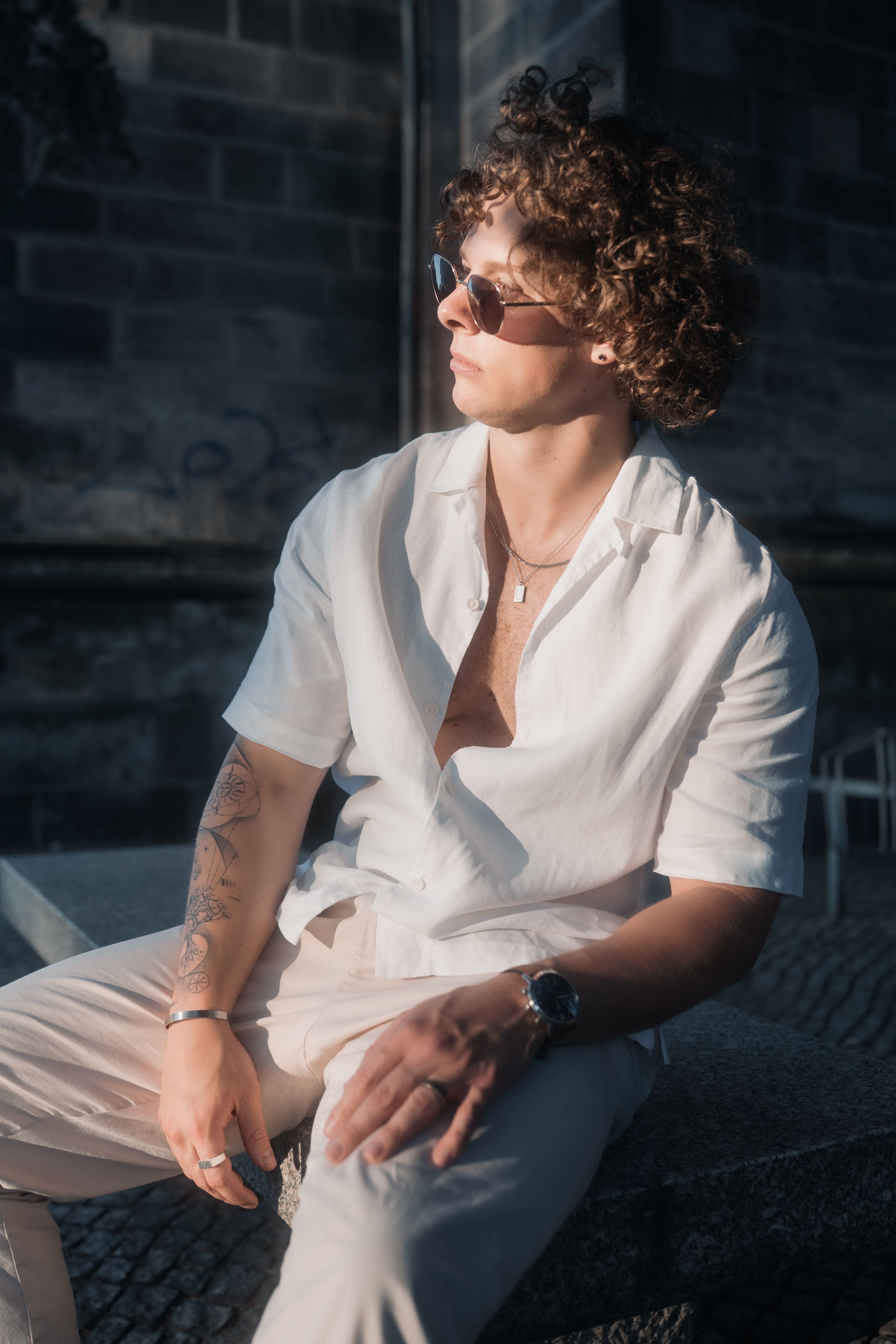 Casual young man with sunglasses enjoying a sunny day in Berlin.