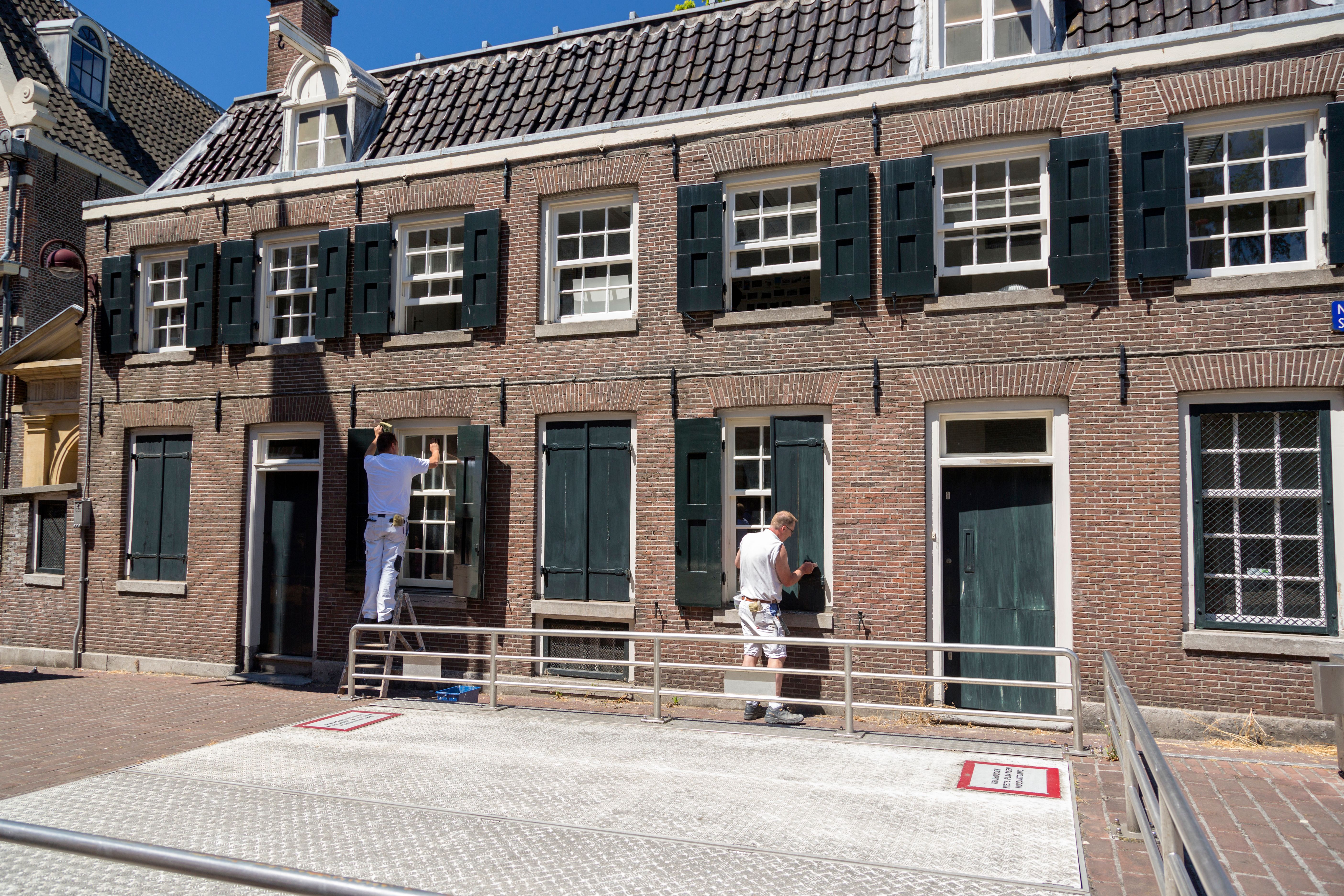 Painters working on a home exterior before applying finish coats