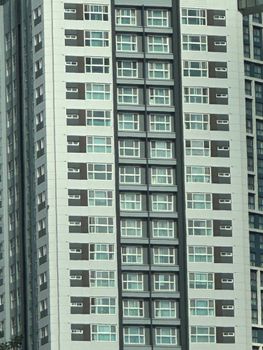 Tall apartment building with uniform windows and modern design.