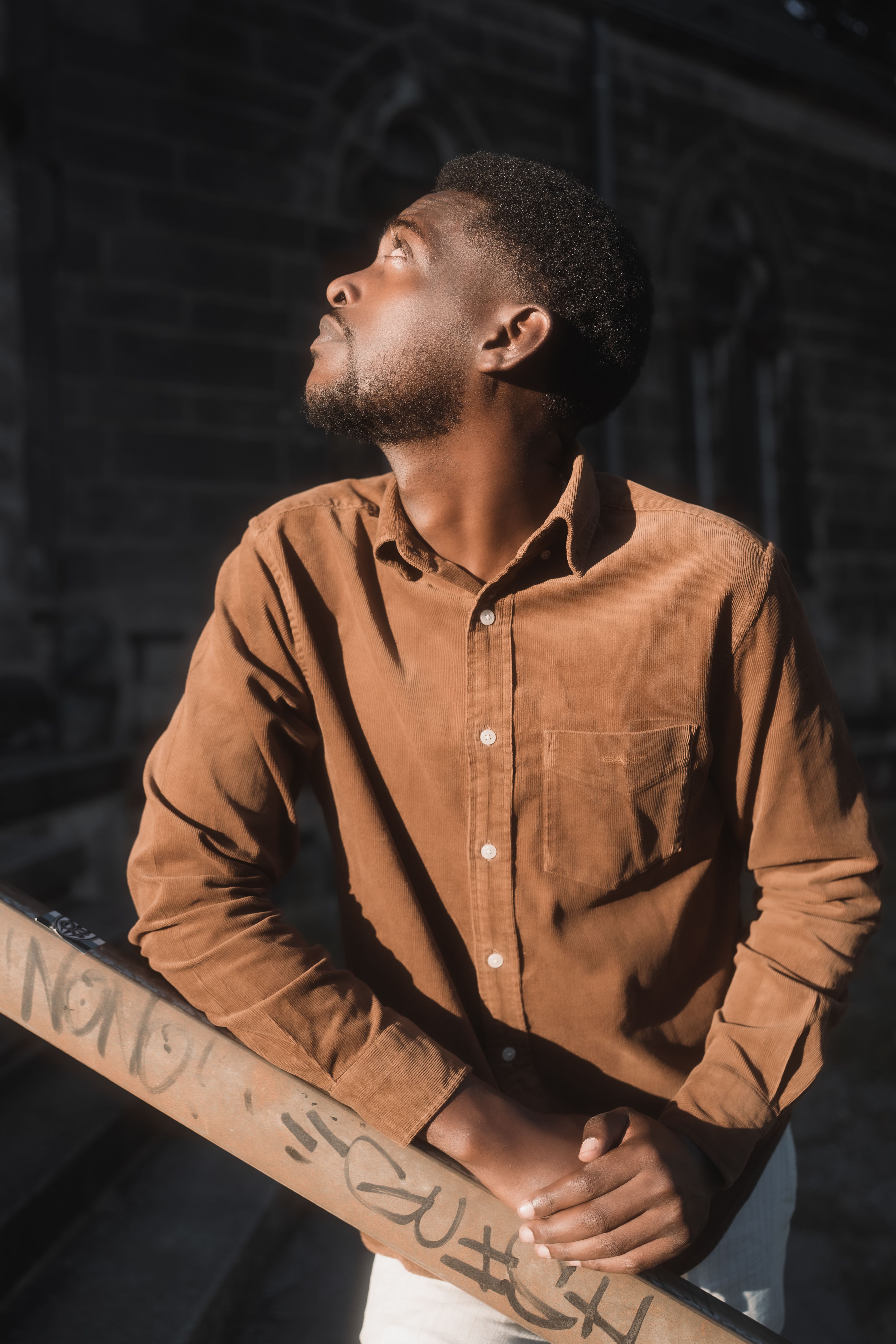 Portrait of a man gazing upwards in a city environment, highlighting thoughtful moments.