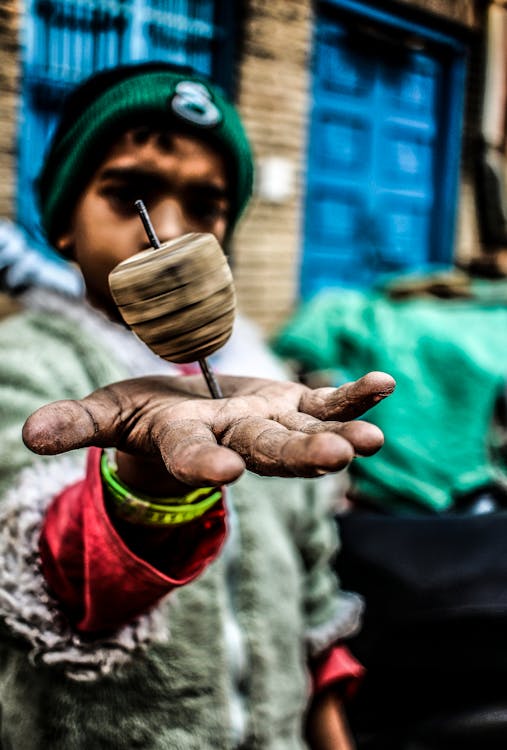 Foto De Enfoque Superficial Del Juguete De Peonza En La Mano Del Niño