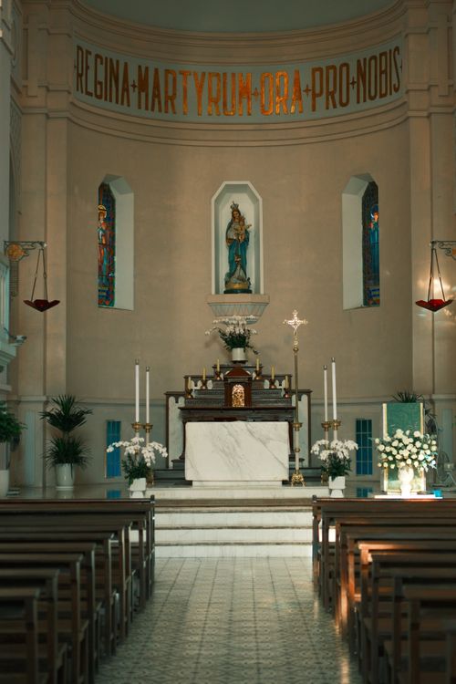 Free A serene view of a Catholic church interior featuring an ornate altar with religious symbols and decorations. Stock Photo