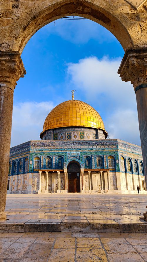 Free Stunning view of the Dome of the Rock with its golden dome through an ancient archway, showcasing Islamic architecture. Stock Photo
