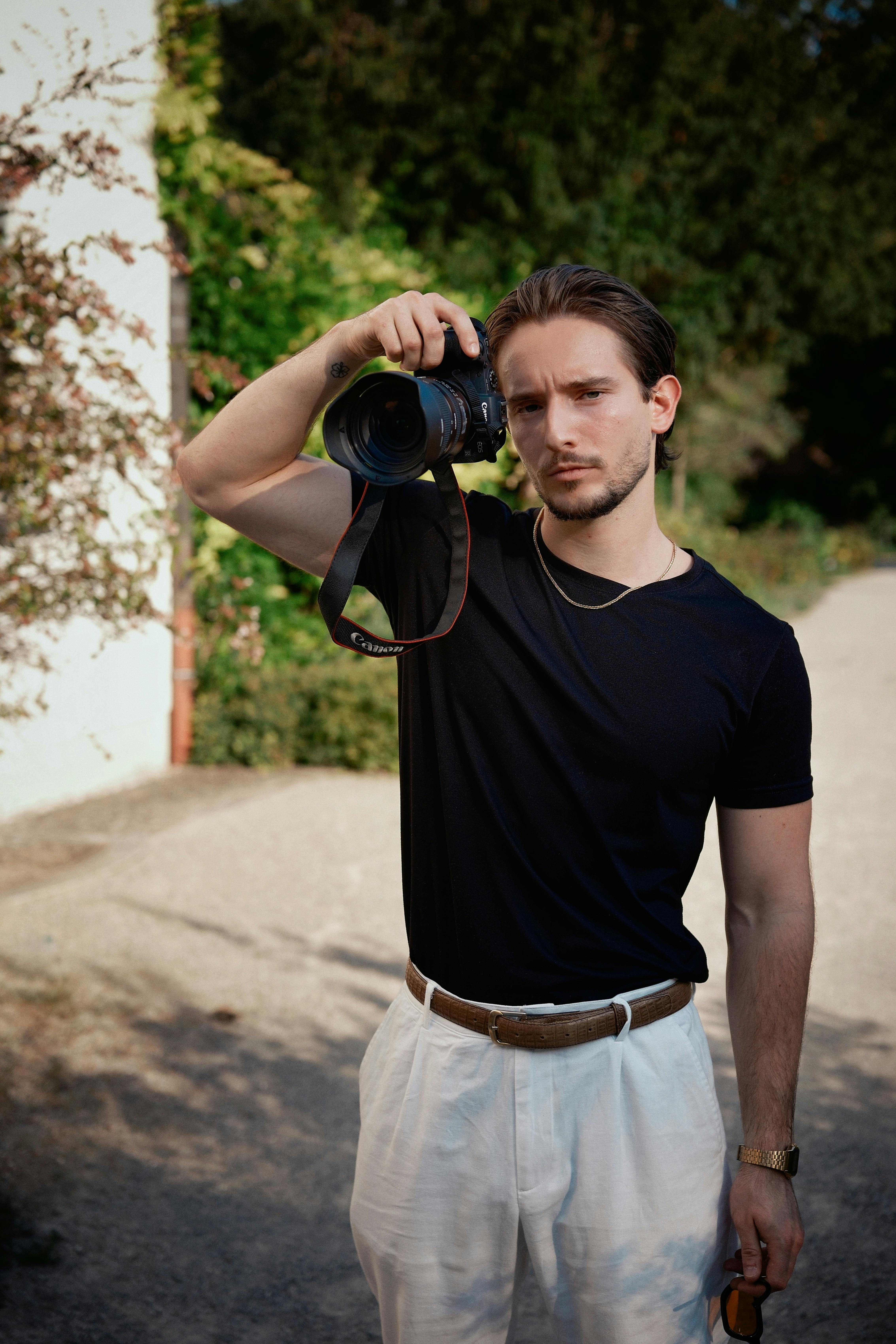young photographer with camera outdoors in summer