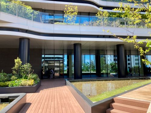 Free A contemporary building with sleek design, glass facade, and natural greenery. Stock Photo