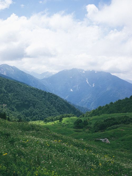 Free Beautiful mountain landscape with green hills and blue sky. Perfect for nature lovers. Stock Photo
