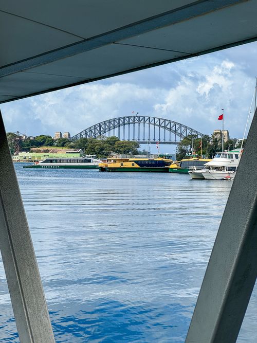 Free Stunning view of Sydney Harbour Bridge framed by marina structures with boats and blue sky. Stock Photo