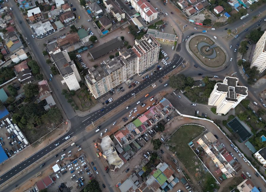 Aerial shot of Maputo cityscape featuring buildings, roads, and roundabout.