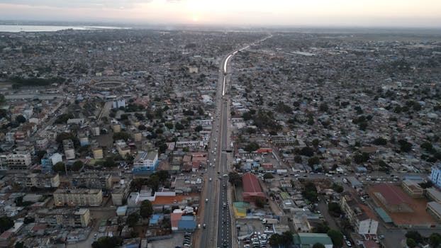 Expansive aerial view of Maputo cityscape at sunrise, showcasing a bustling urban environment.