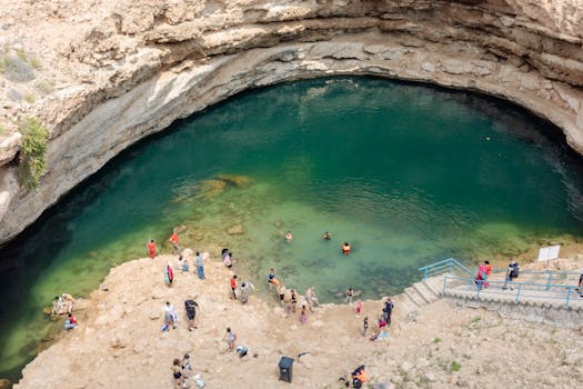 Tourists enjoy swimming in Bimmah Sinkhole, a natural attraction in Oman.