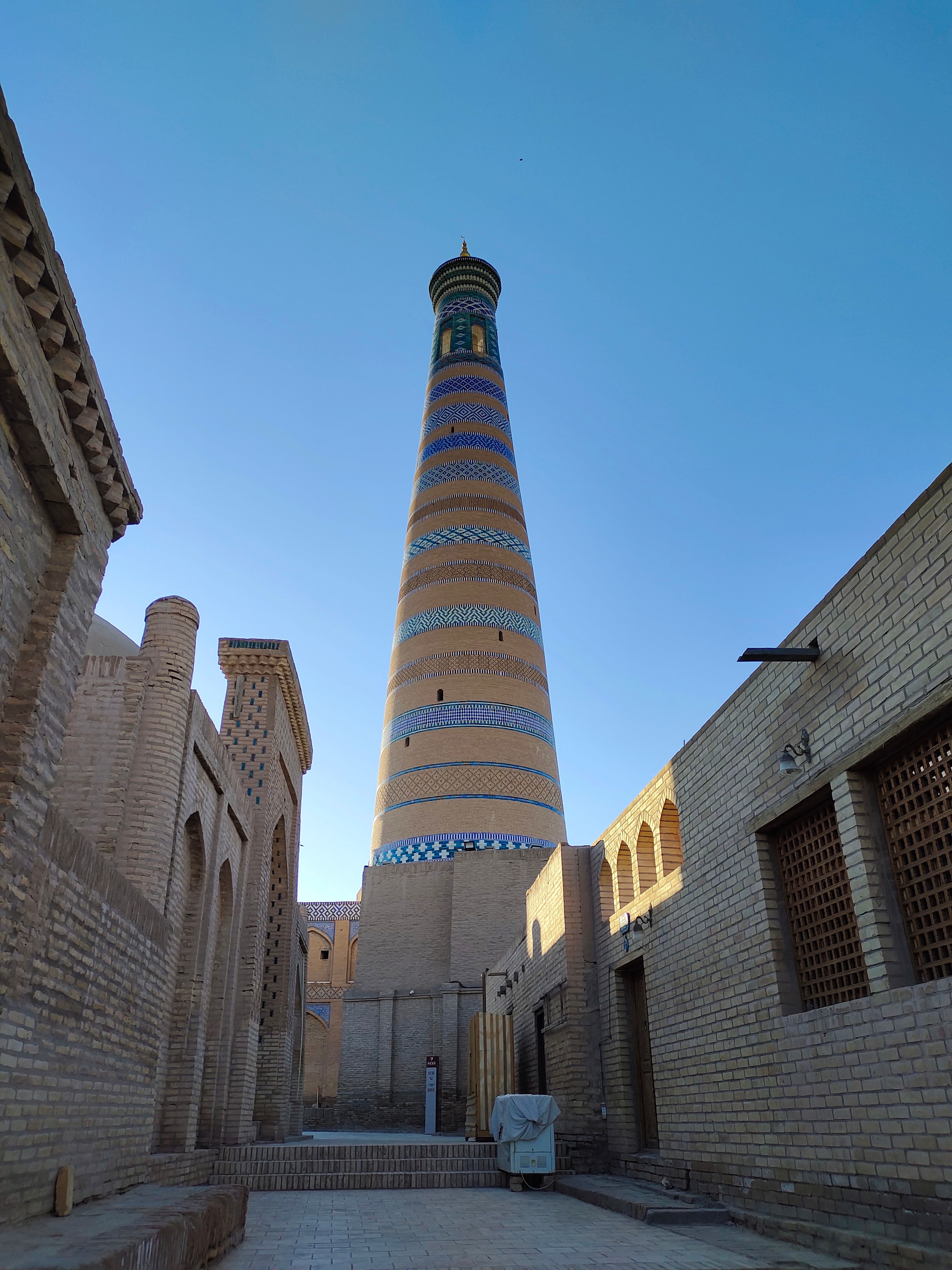 Stunning view of the iconic Kalta Minor Minaret in Khiva, Uzbekistan, captured under a bright blue sky.