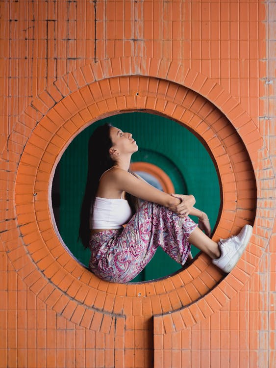 Free Woman Sitting in Wall Hole Stock Photo