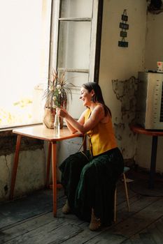 Relaxed bohemian woman in a cozy Baku cafe, embracing a summer vibe.