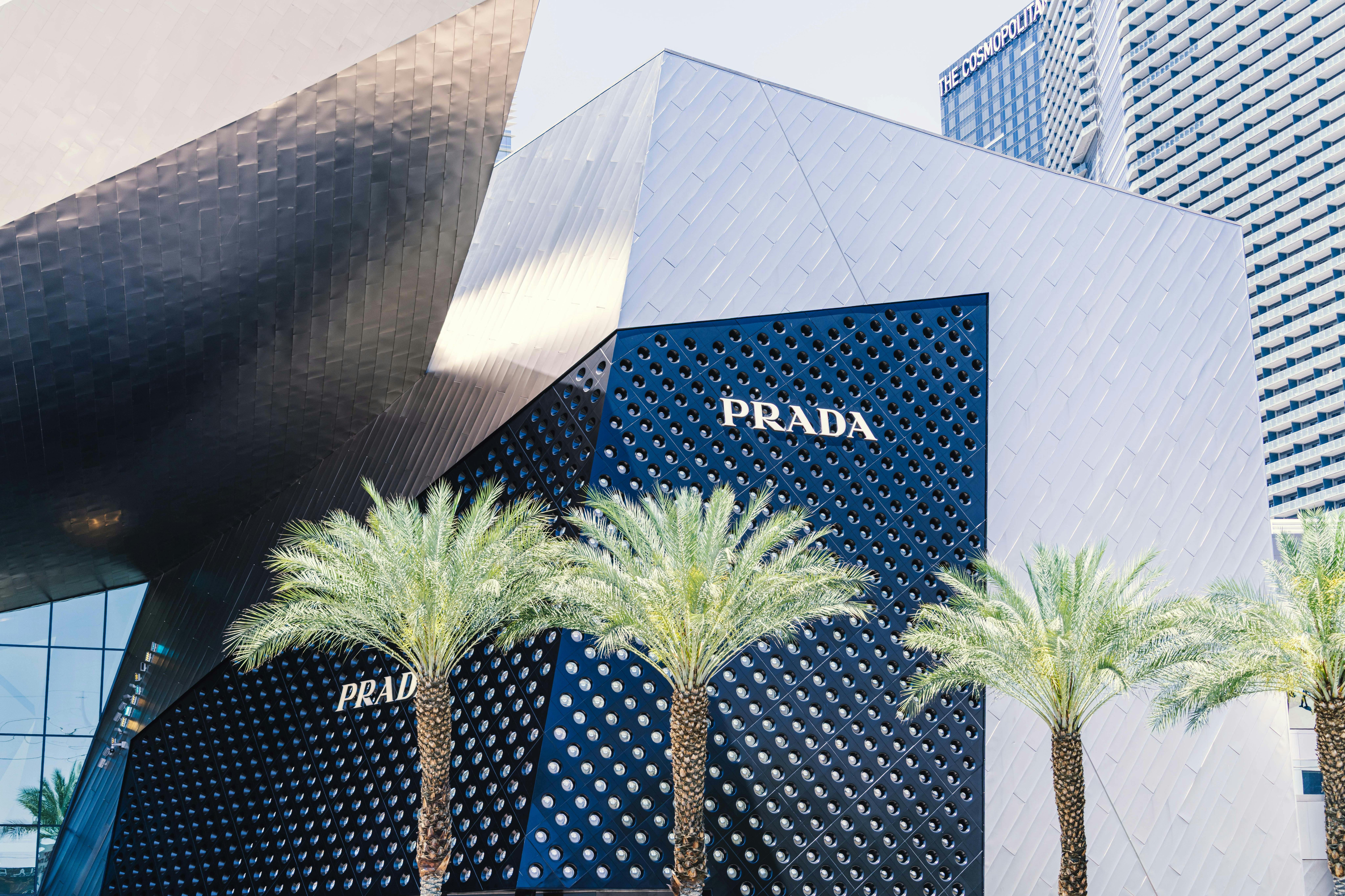 Contemporary architecture of the Prada storefront on Las Vegas Strip with palm trees and unique design.