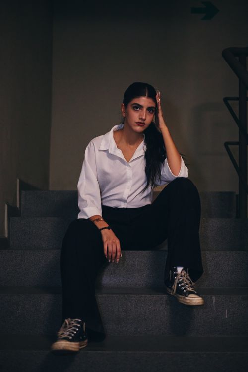 Free Fashionable woman sitting on stairs with confident expression in İstanbul. Stock Photo