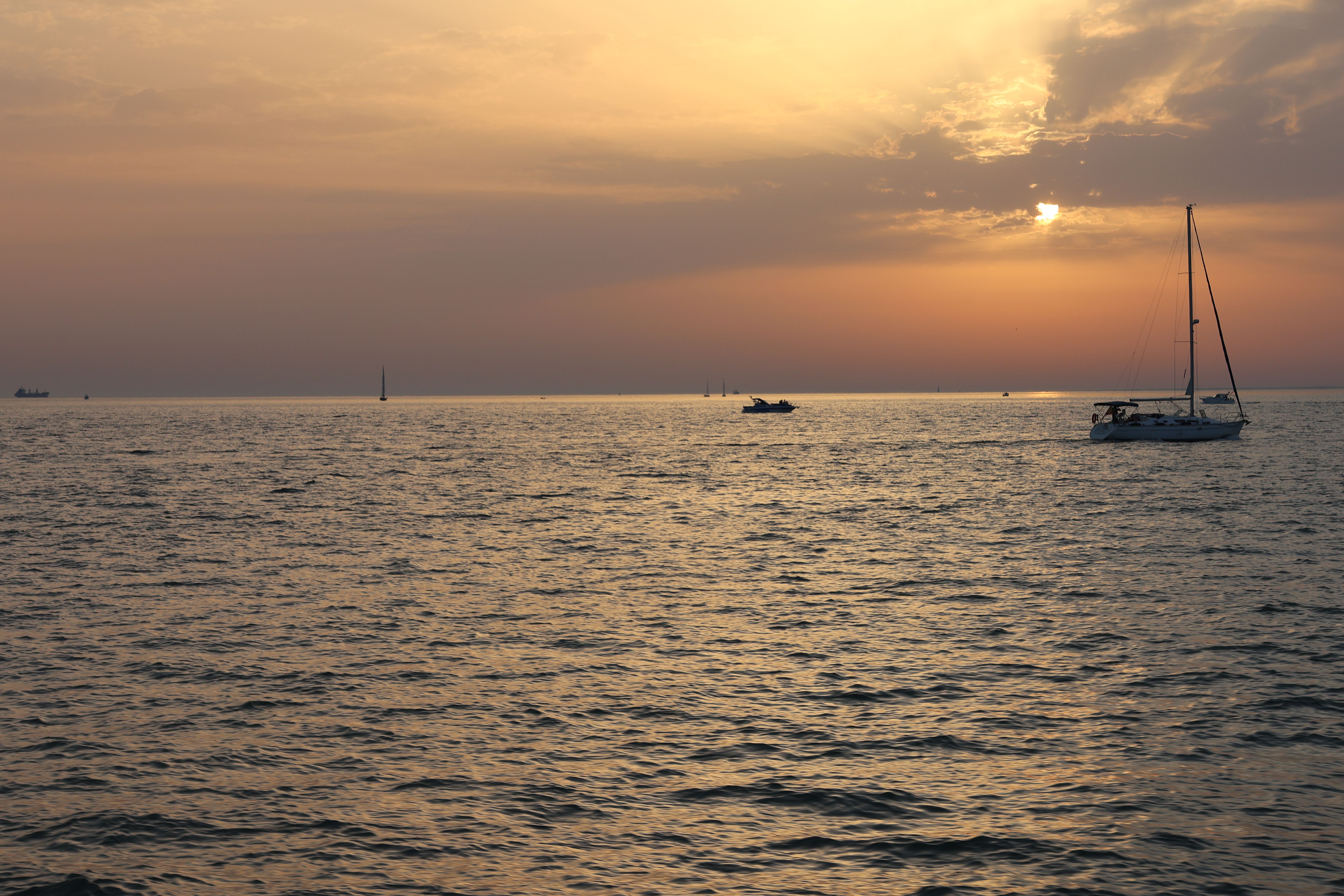 Tranquil sunset over a bay with sailboats at anchor