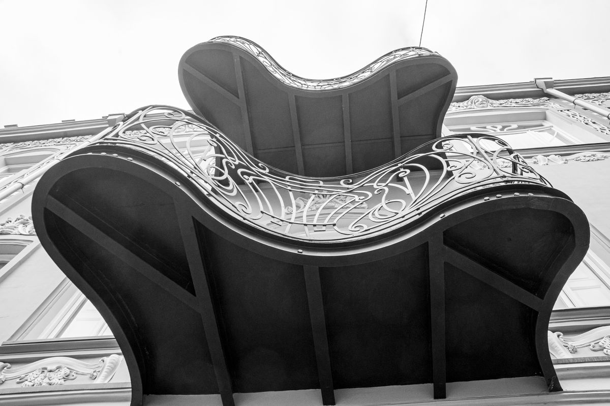 Balcon de fier forjat cu linii curbe văzut de dedesubt