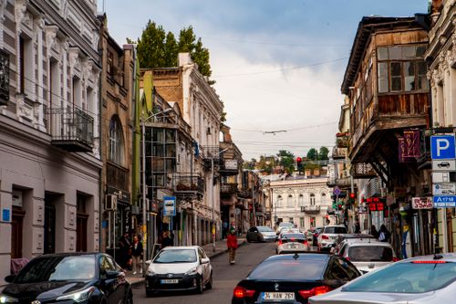 Free European street scene with historic buildings and bustling traffic under a vibrant sky. Stock Photo