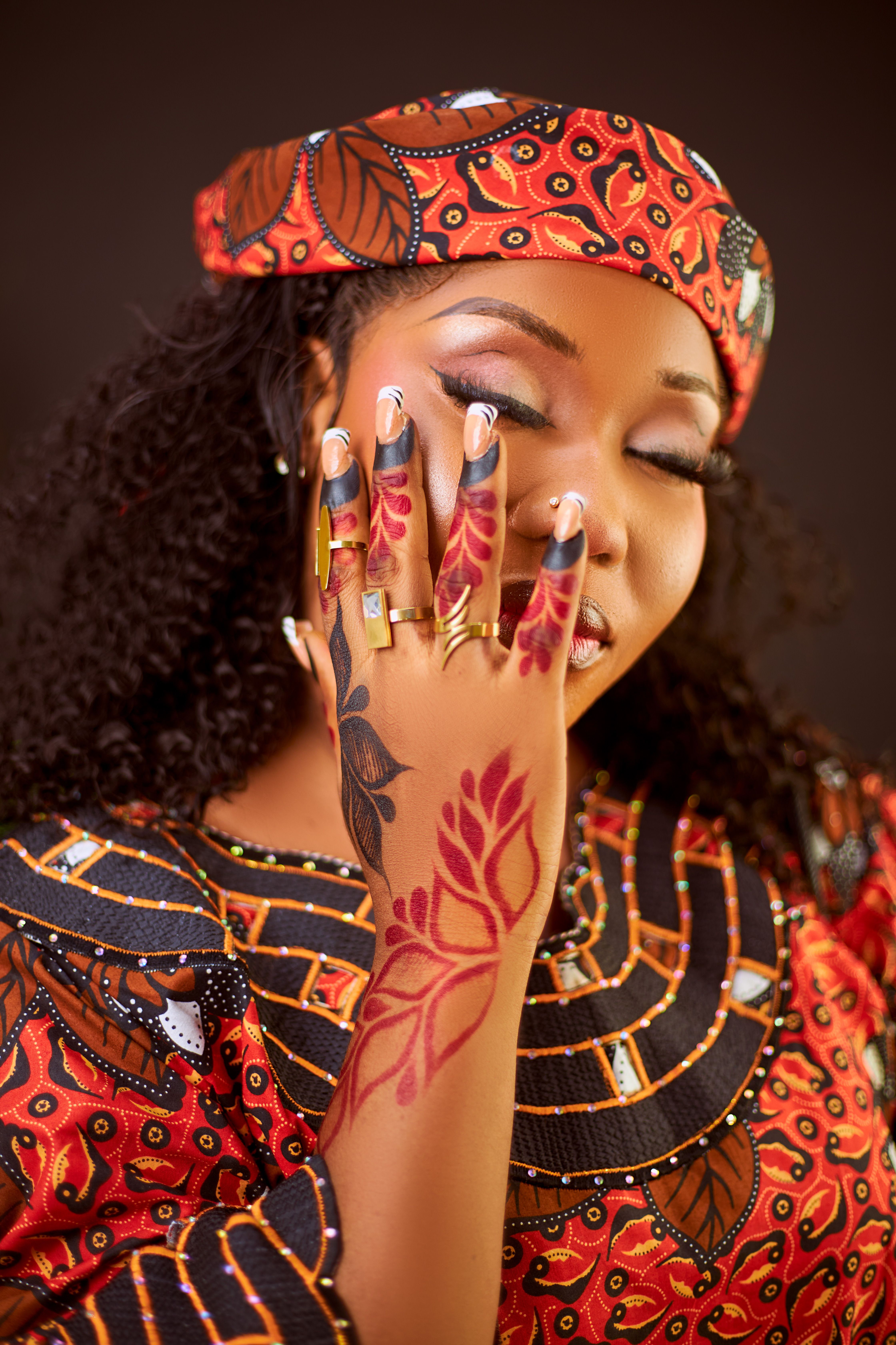 Portrait of a woman in African attire with intricate henna art showcasing cultural beauty.