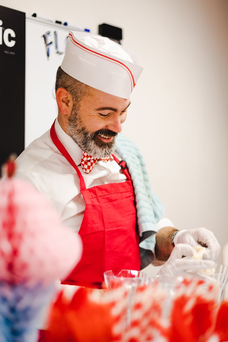 A Chef In Red Apron With A Smile On His Face