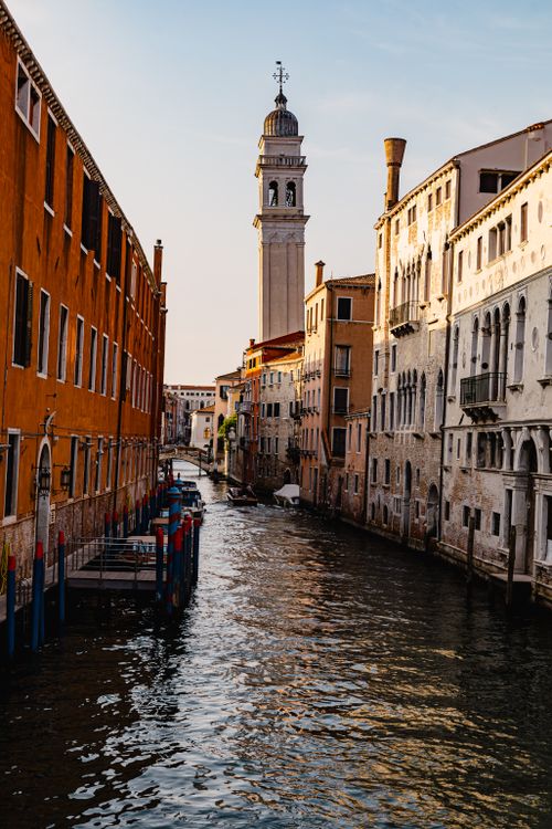 Free Charming canal in Venice, Italy with a view of historic buildings and a bell tower at sunset. Stock Photo