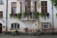 Charming historic building facade adorned with vibrant flower arrangements in window boxes.