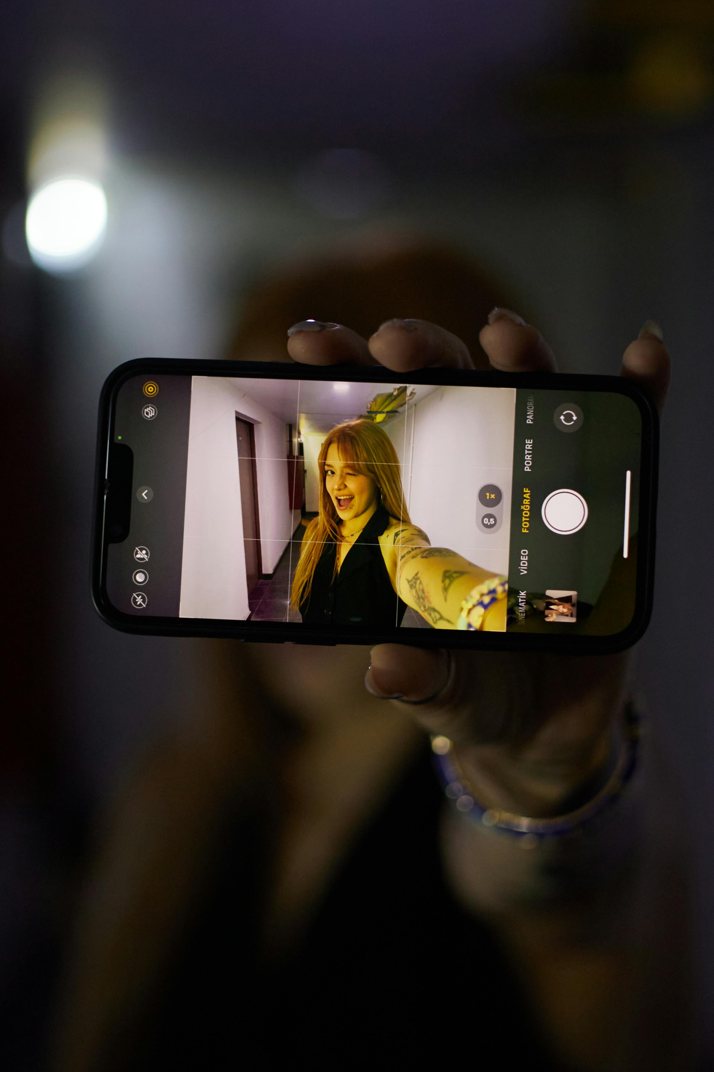 Free Young woman taking a selfie indoors in İstanbul, Türkiye. Vibrant and modern setting. Stock Photo