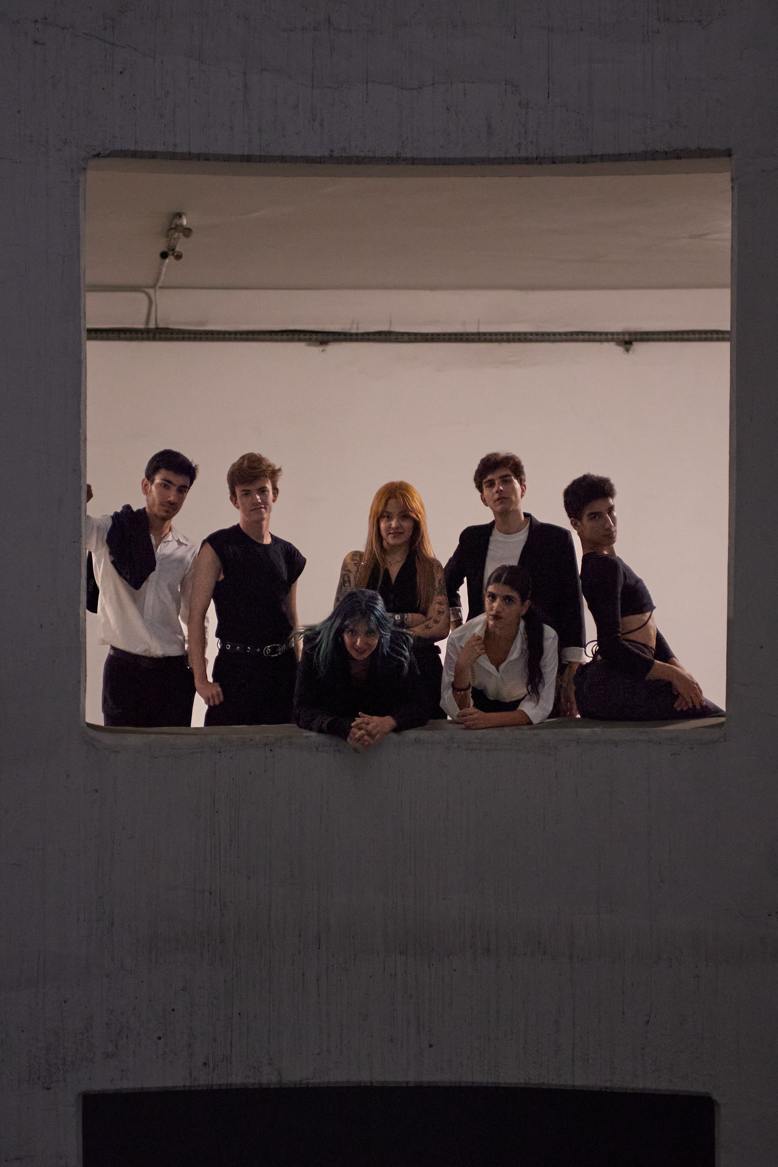 Diverse group of young models posing in a studio with stylish outfits.
