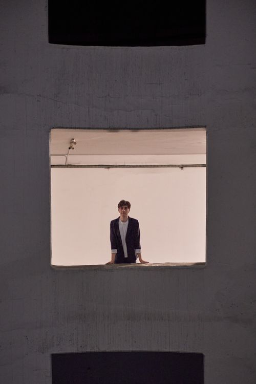 Free Portrait of a young man standing in a window frame, showcasing modern style and architecture in Istanbul. Stock Photo
