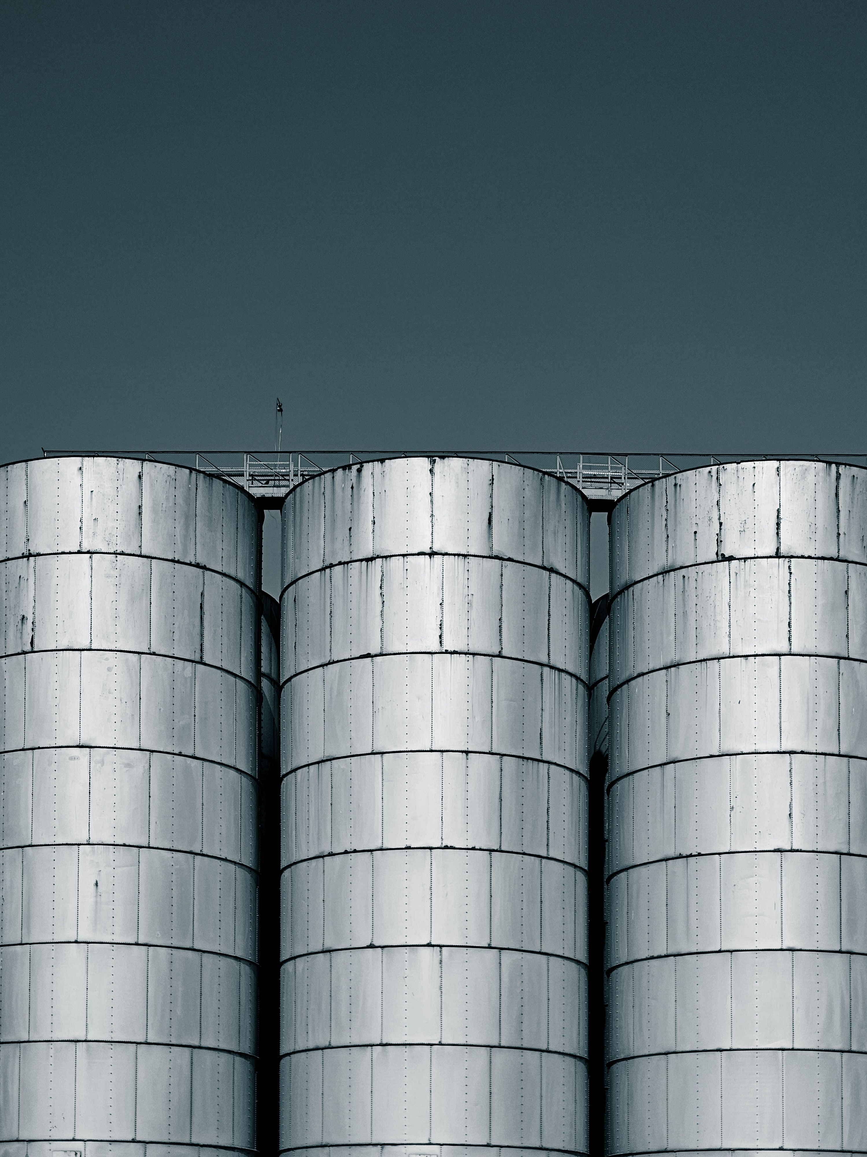 Industrial Silos Against Clear Sky · Free Stock Photo