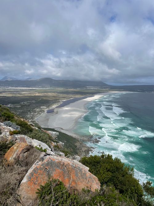 Free Breathtaking coastal landscape with rocky shore, waves, and vast horizon under cloudy sky. Stock Photo